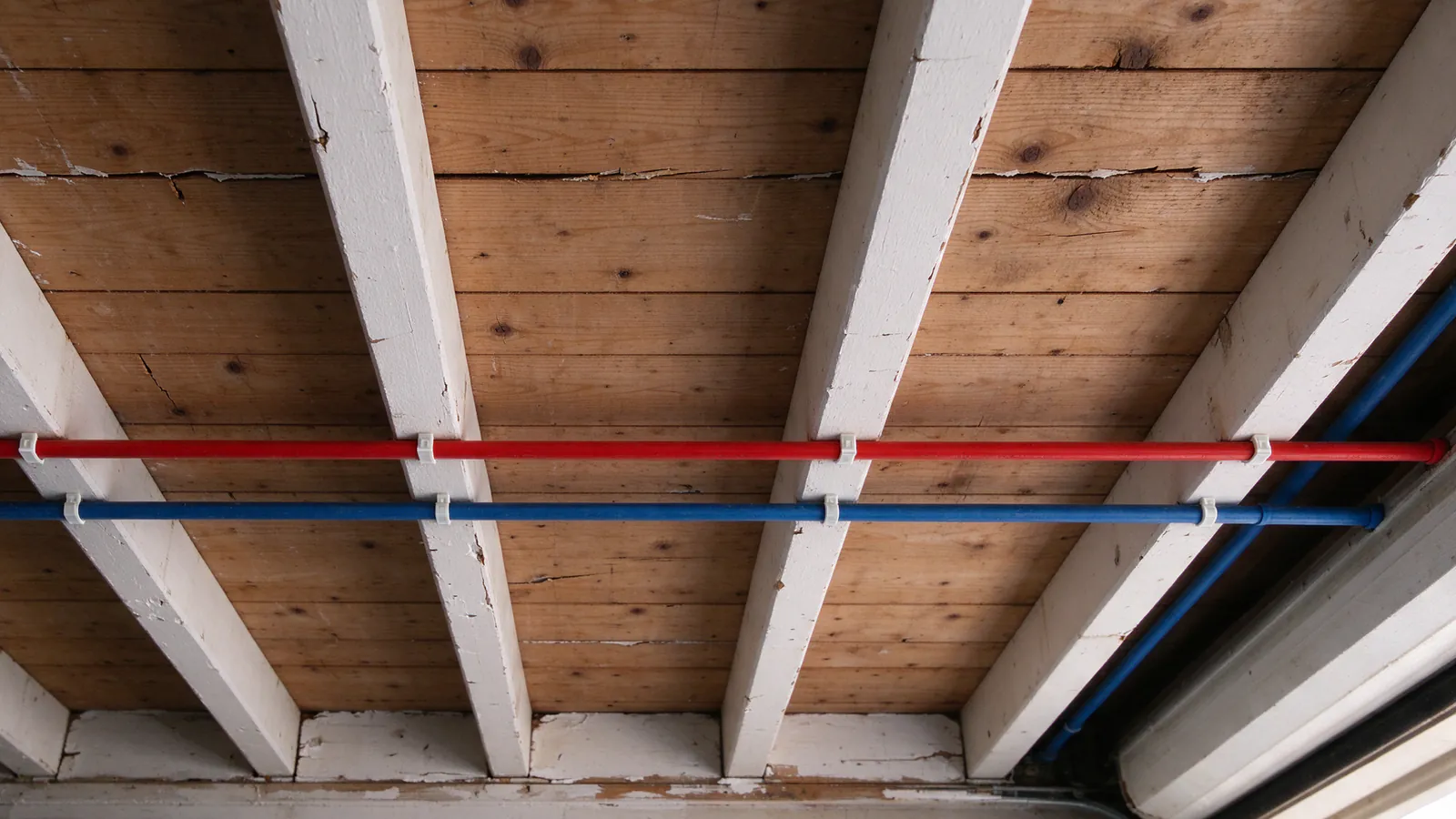 New PEX trunk lines replacing old pipe across garage ceiling joists